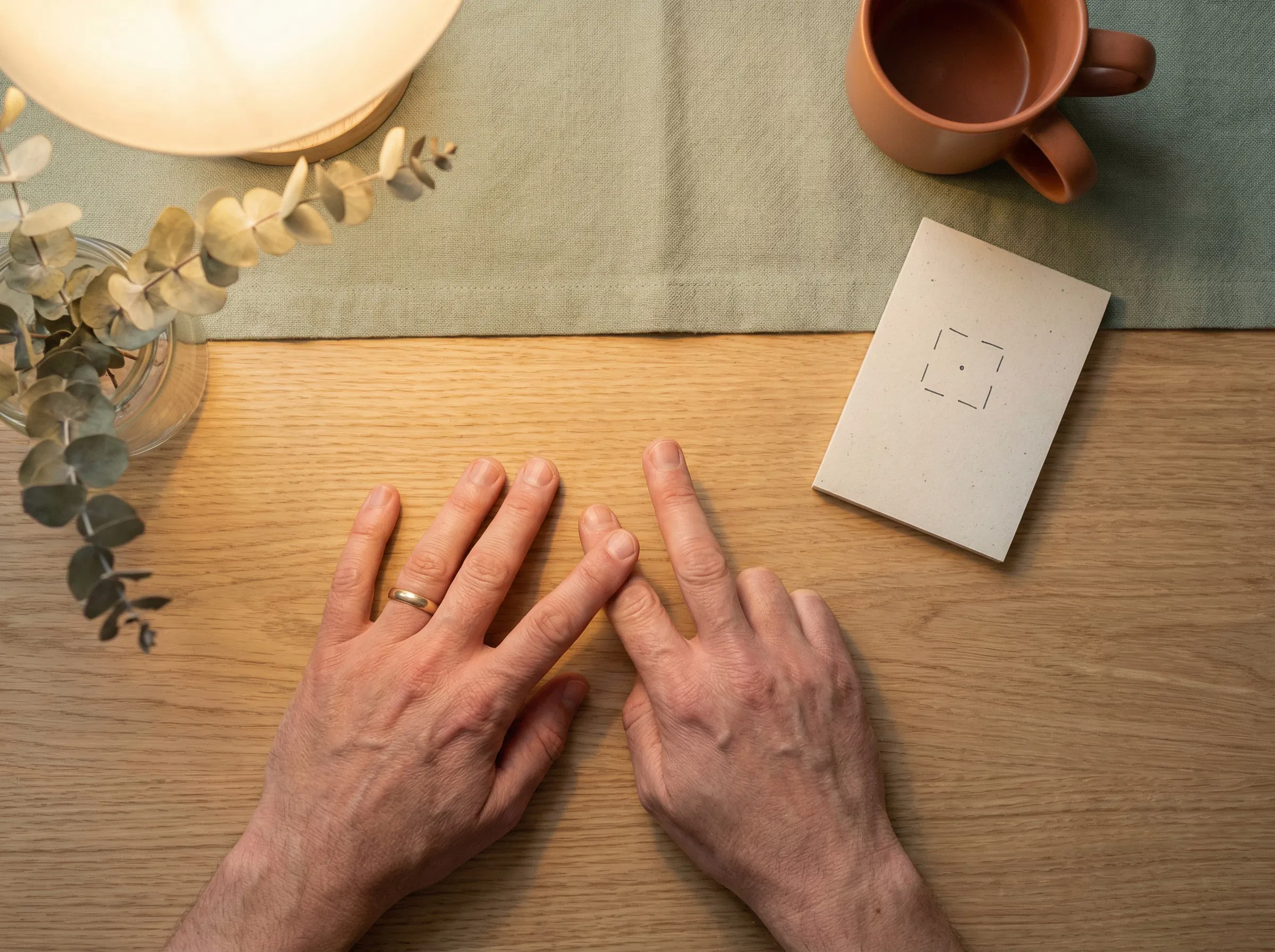 HĂ¤nde ruhen auf dem Schreibtisch mit vier ausgestreckten Fingern und zĂ¤hlen den Box-Breathing-Rhythmus
